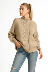 Woman wearing a beige cable knit turtleneck sweater with relaxed fit, cozy fall outfit